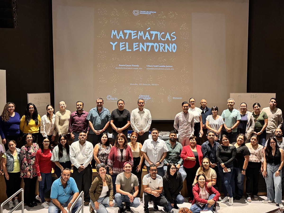 Auditorio de docentes con la portada del libro proyectada